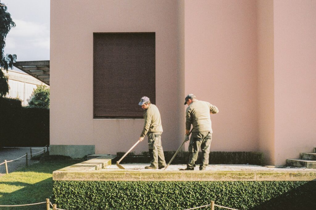 Photo avec deux hommes entrain de faire un nettoyage exterieur - Jardinier - paysagiste